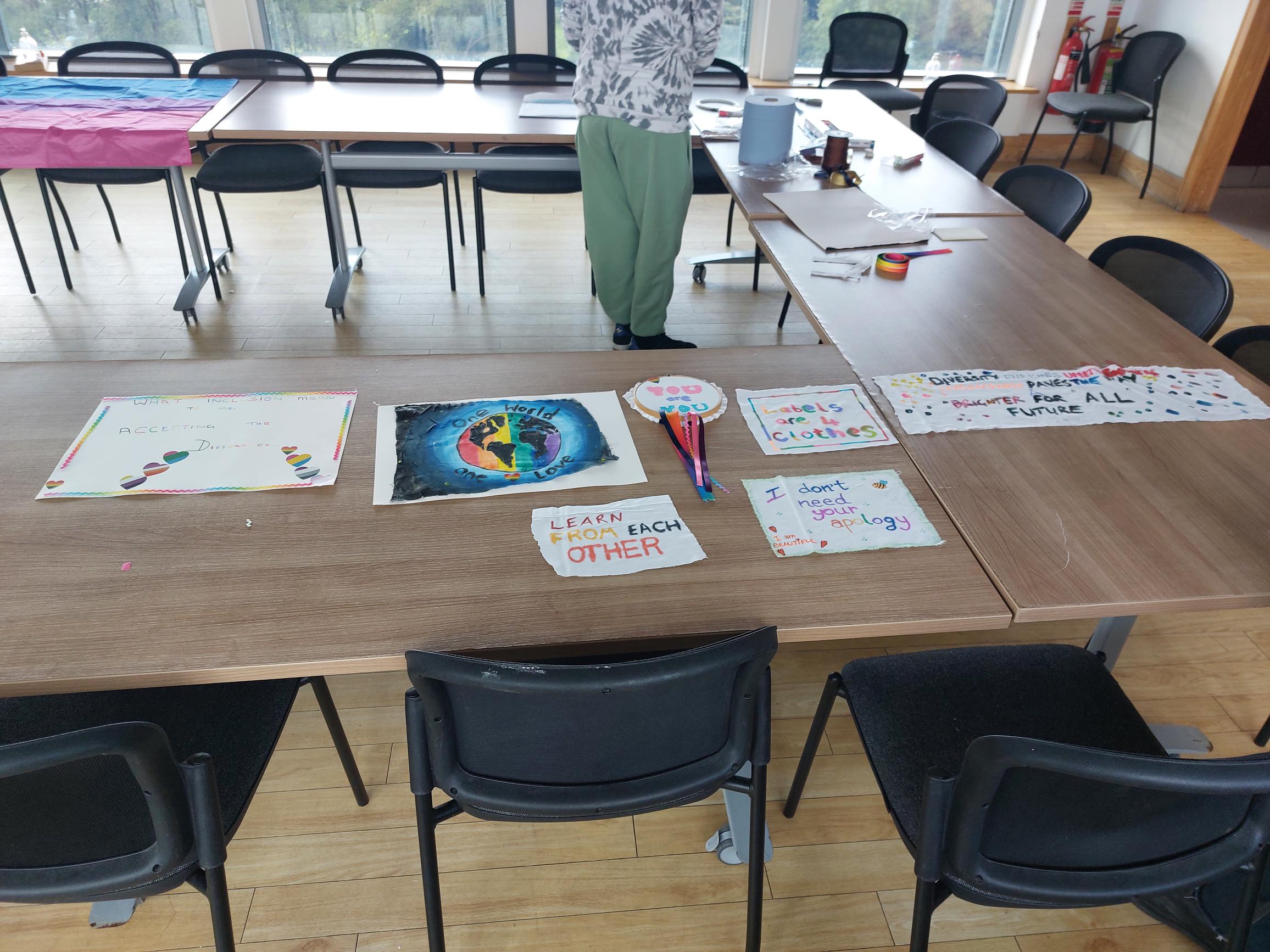 College student looking at craft material with drawings on tables