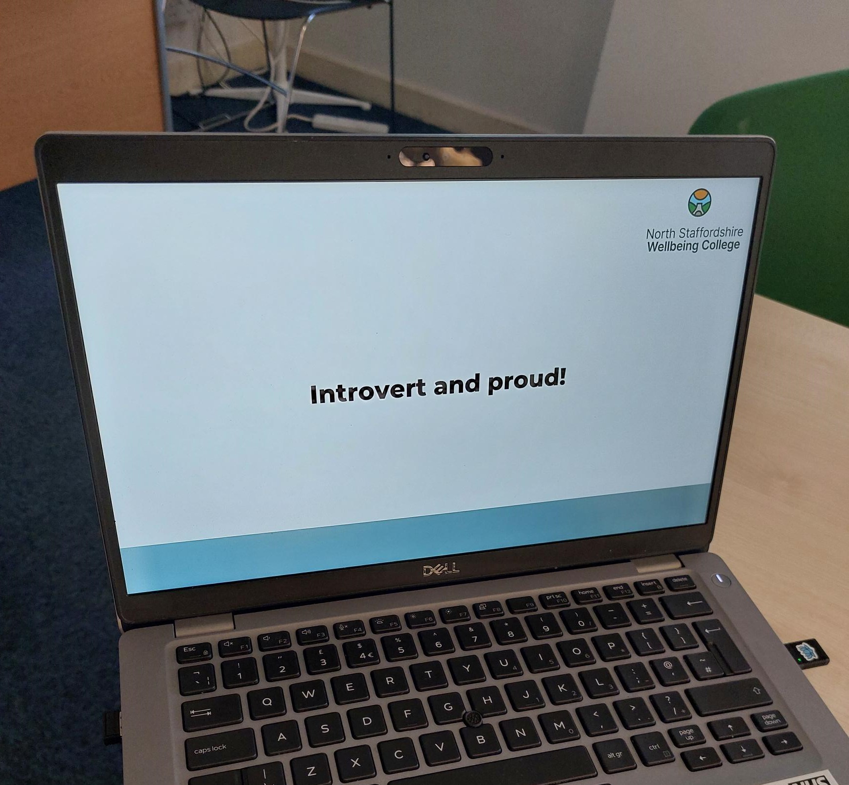 Laptop on table with screen saying 'Introvert and proud'