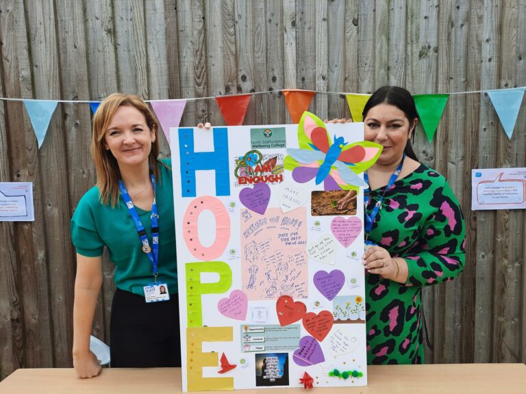 Two members of College staff holding a poster saying HOPE and crafts from inpatient bite-sized workshop around recovery